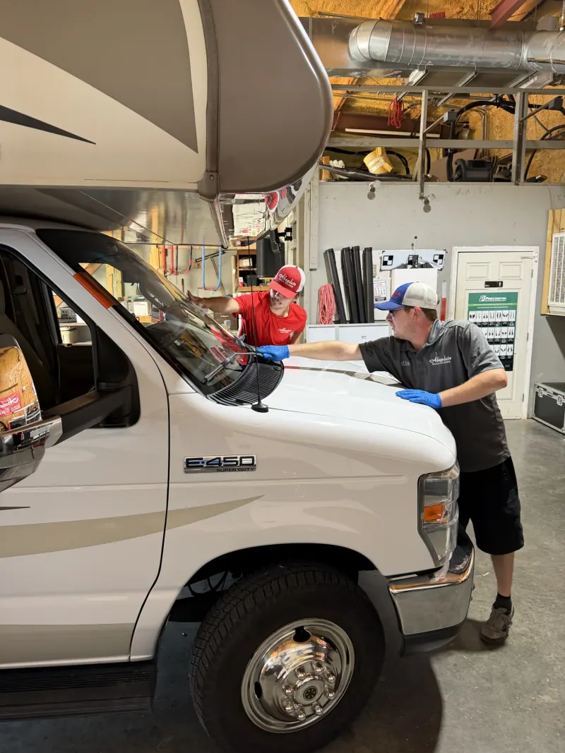 Absolute Auto Glass technicians working on an RV windshield