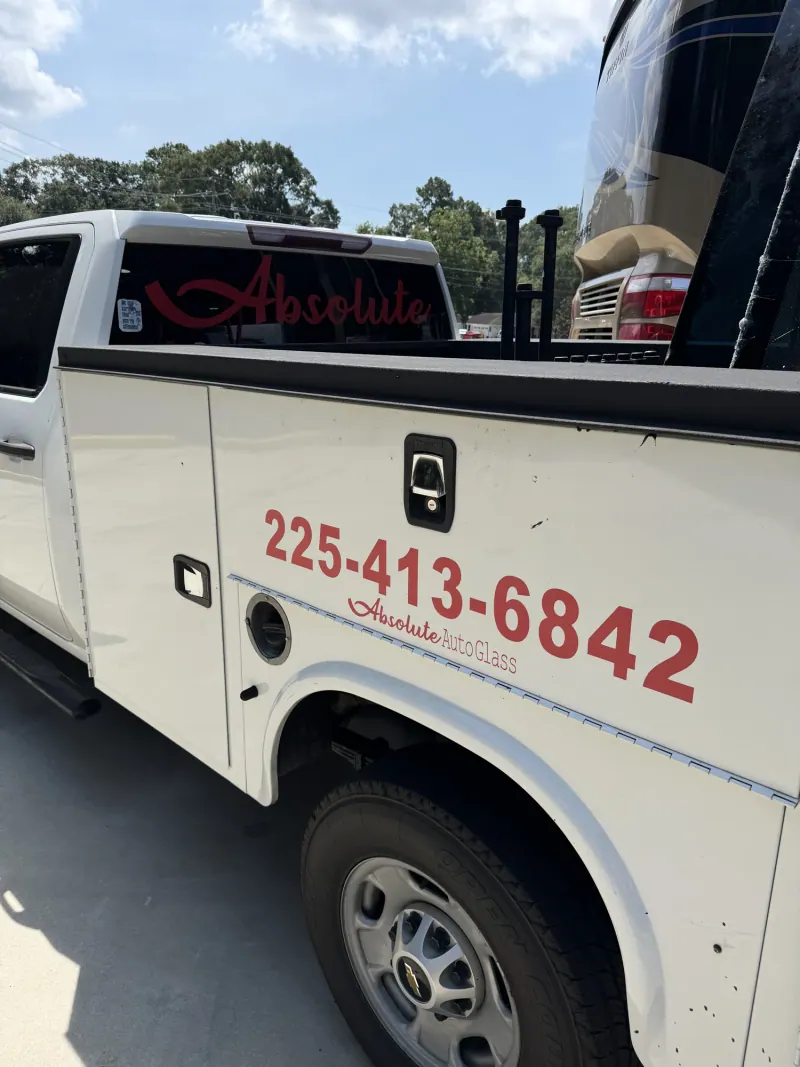 Branded Absolute Auto Glass service truck beside a motorhome